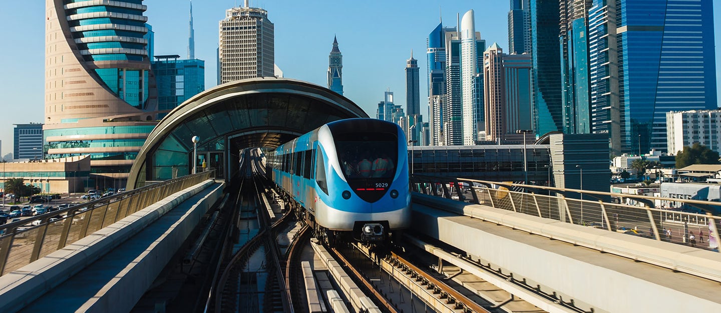 Dubai Metro train on the Red Line operating the new direct service, showing passenger flow on the platform during peak hours.