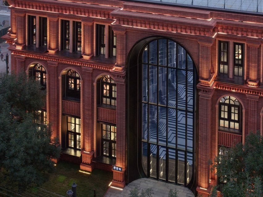 Zhongshuge Bookstore at night: red brick, arched windows, warm glow.