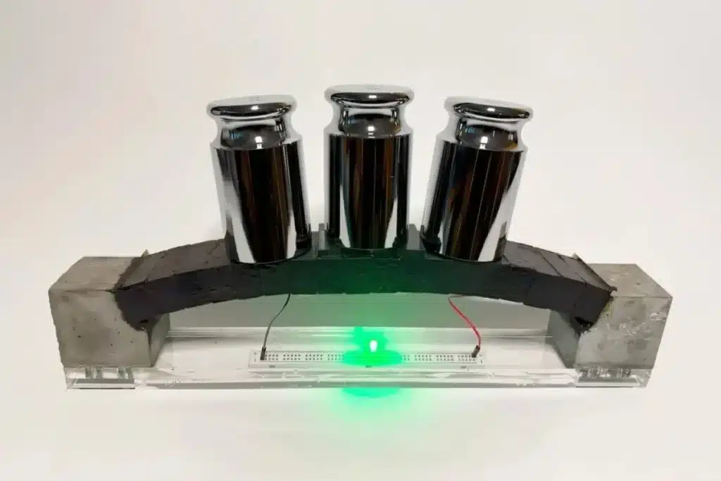 جسر صغير من خرسانة ذكية يشغّل ضوء LED أخضر تحته.