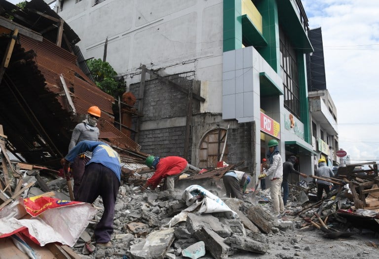 Rescue teams search through collapsed buildings after the powerful earthquake in the Philippines.