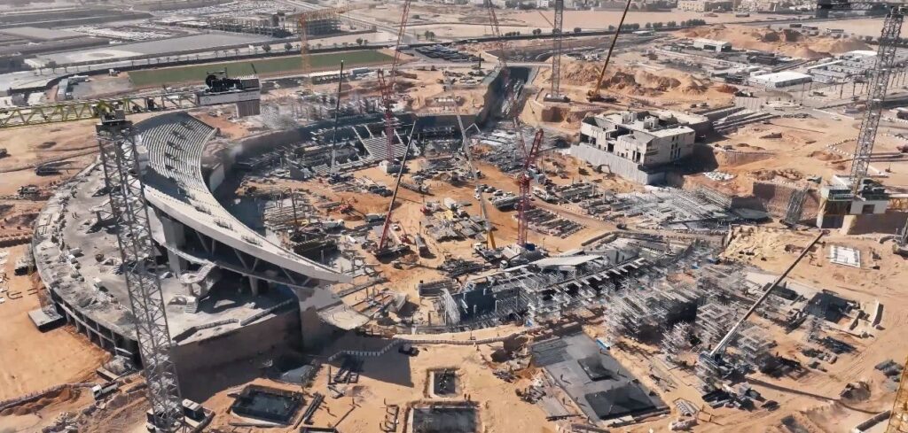 صورة جوية تُظهر أعمال الإنشاءات الجارية في مدينة الملك فهد الرياضية بالرياض، حيث يُعاد تطوير الملعب الرئيسي بتوسيعه وتحديثه، مع ظهور رافعات وأعمال بناء مكثفة حول المدرجات.