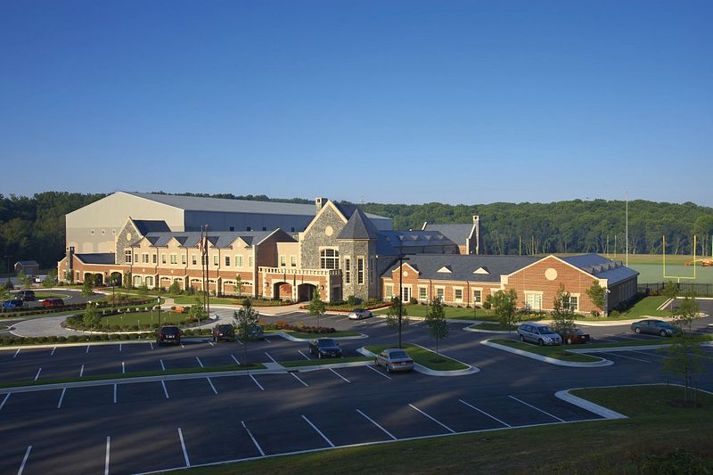 مركز تدريب ريفنز في صبيحة هادئة &mdash; مباني من الطوب والحجر، موقف سيارات خالٍ، وملاعب خضراء تمتد بين الأشجار. هدوء يسبق القوة.