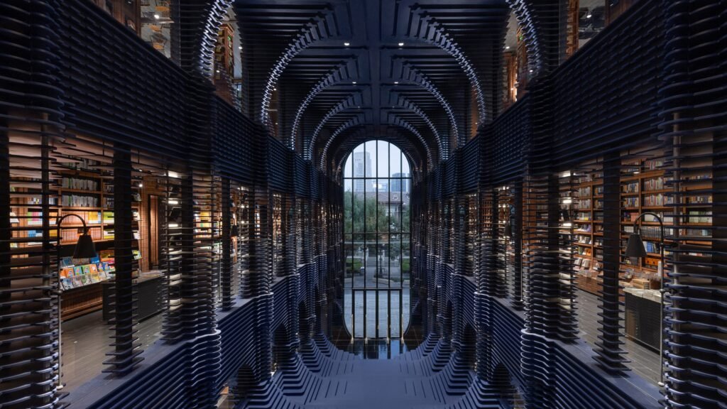 داخل مكتبة الكتب المركزية  رفوف موجية سوداء تشكل نفقًا يقود للنور والخارج.