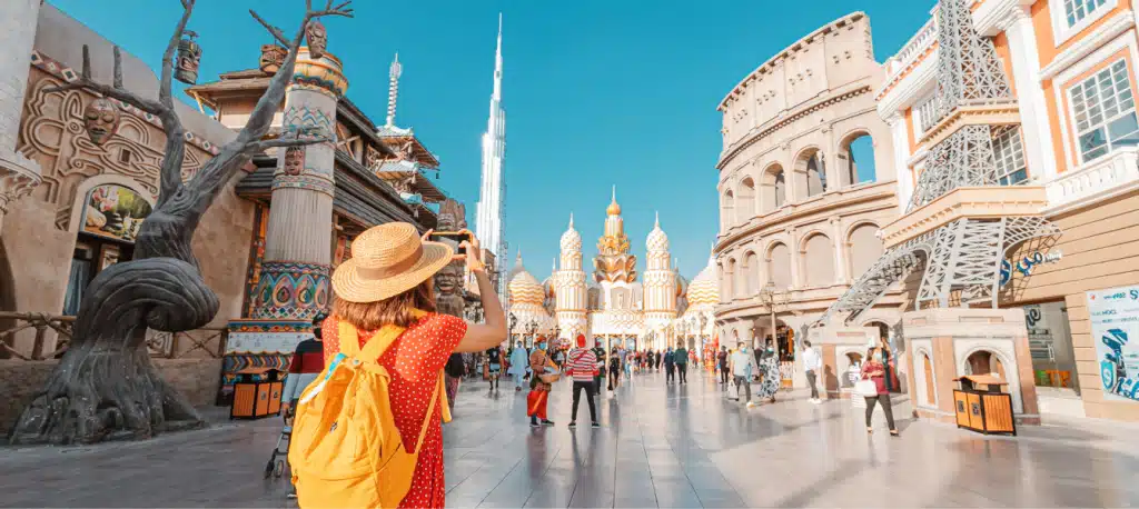 مشهد جوي للقرية العالمية يظهر المساحات الخضراء والمناطق الترفيهية من الأعلى.