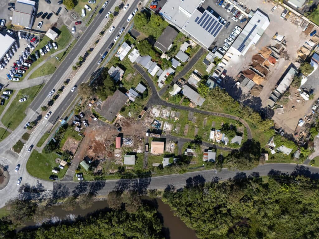 Aerial view of Solhaven&rsquo;s future site &mdash; empty land beside road and river.