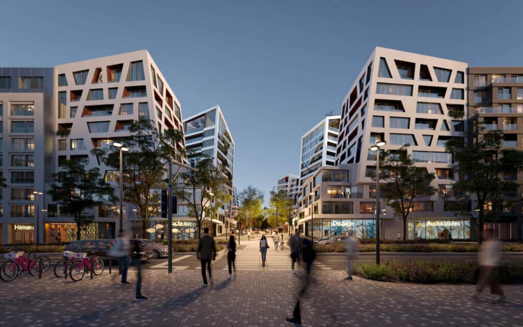 A lively urban street in Prague lined with modern residential buildings and ground-floor shops at dusk.