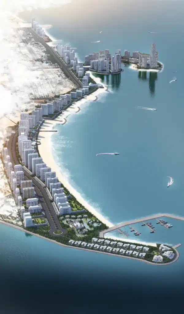 رؤية جوية شاملة لمشروع "داون تاون أم القيوين" يظهر فيها امتداد الأبراج الحديثة على طول الشاطئ، مع جزر صناعية، مرسى قوارب، شواطئ رملية، وطرق مرصوفة تربط بين المناطق &mdash; كلها تتوسط مياه زرقاء هادئة تحت ضوء الشمس الدافئ.