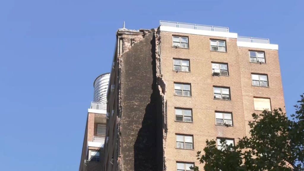 Fire trucks stationed outside the partially collapsed Bronx building
