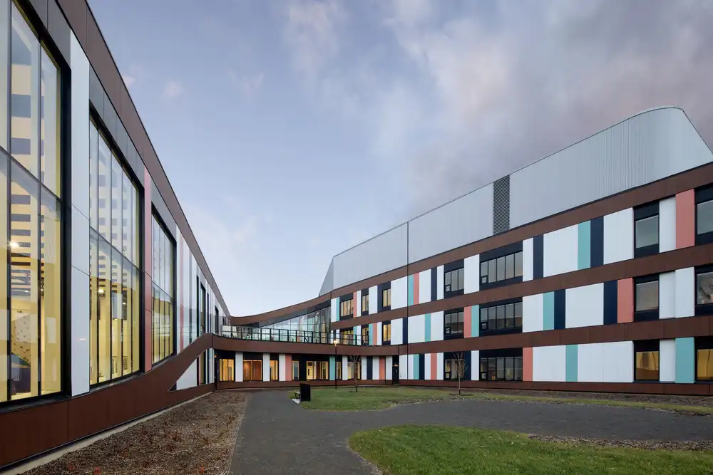 Courtyard view of CRJDA Sainte-Thérèse — colorful wings, glass walls, and calm green space.