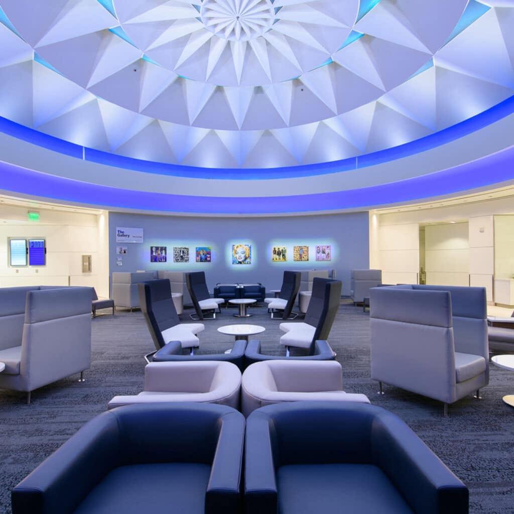 صالة انتظار في محطة لوس أنجلوس 5 سقف هندسي، مقاعد عصرية، وجدران فنية مُضيئة.
