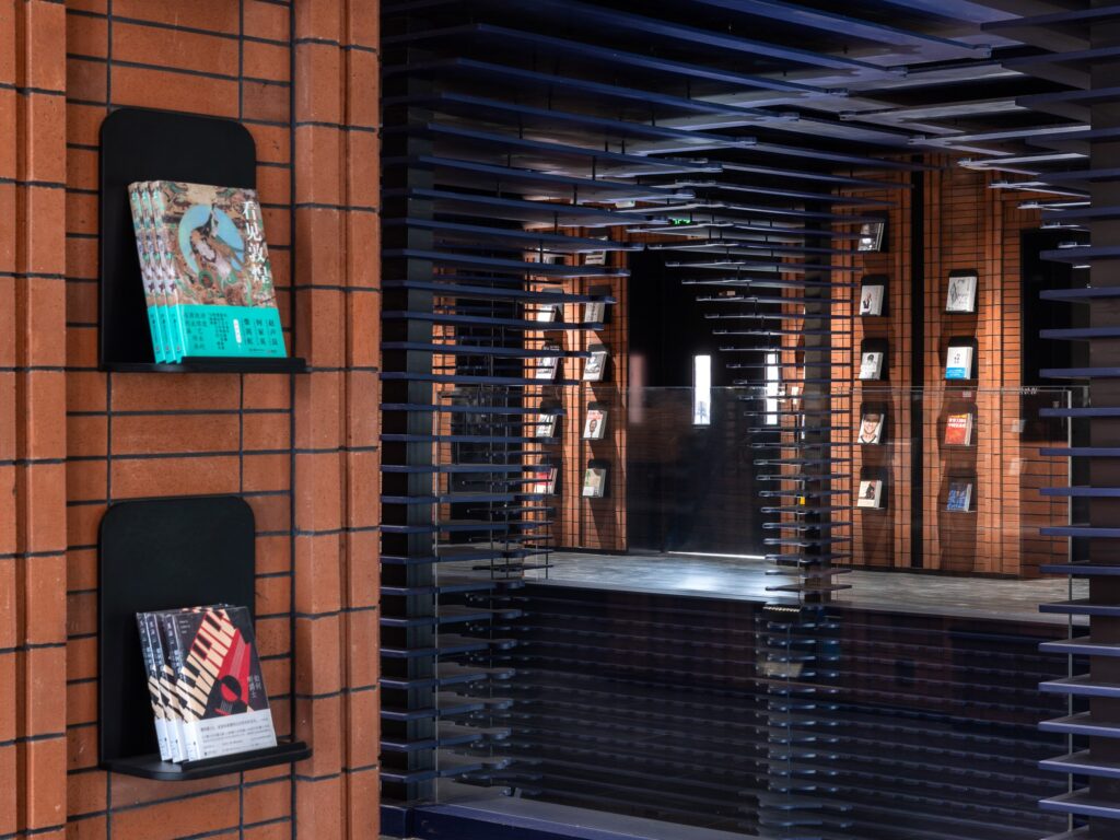 Close-up inside Zhongshuge: red brick walls, floating black shelves, books displayed like art.