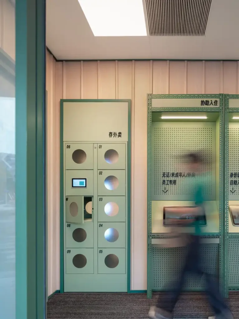 Guestroom interior of Hi Inn featuring exposed concrete, neutral tones, and compact spatial organization.