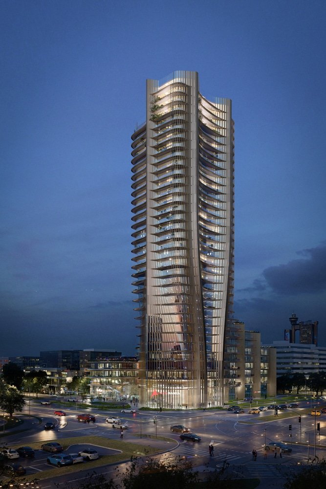 Alta Bank Tower glows at dusk, its wavy façade lit from within, standing tall over a busy intersection with cars and pedestrians below under a deep blue sky.