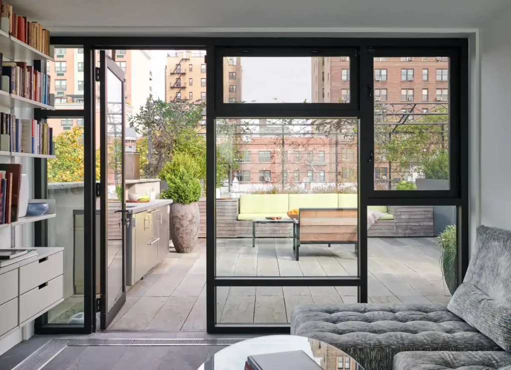 منظر جانبي للمنزل يظهر التوسعات المعدنية السوداء ونوافذ الزجاج المقسمة بأسلوب موندريان.