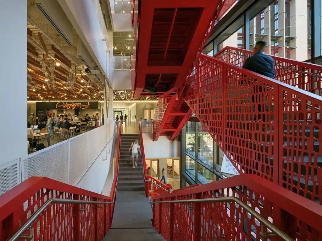 View from above: Stanford’s red staircase connects floors, overlooking the Voyager Coffee café and study areas.