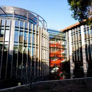 Stanford’s exterior: sleek glass and vertical fins, with a hint of the bold red staircase visible inside.