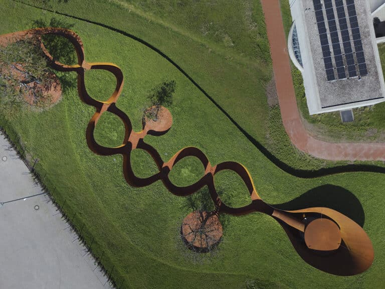 Doshi Retreat at Vitra, a pavilion made of corten steel and minimalist forms seen in the green countryside