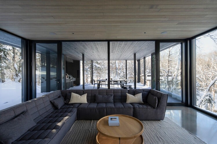 Residential building in Laurentians integrated with surrounding nature and interior spaces.