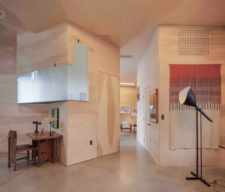 L-shaped house fa&ccedil;ade clad in corrugated aluminum reflecting sunlight