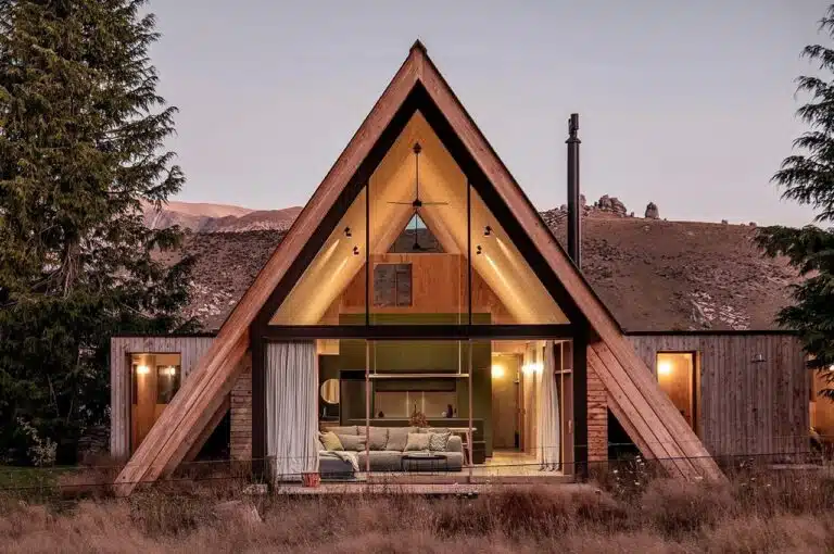 Exterior view of Adventure Whare resort surrounded by trees and forests, featuring traditional A-frame design with modern touches.
