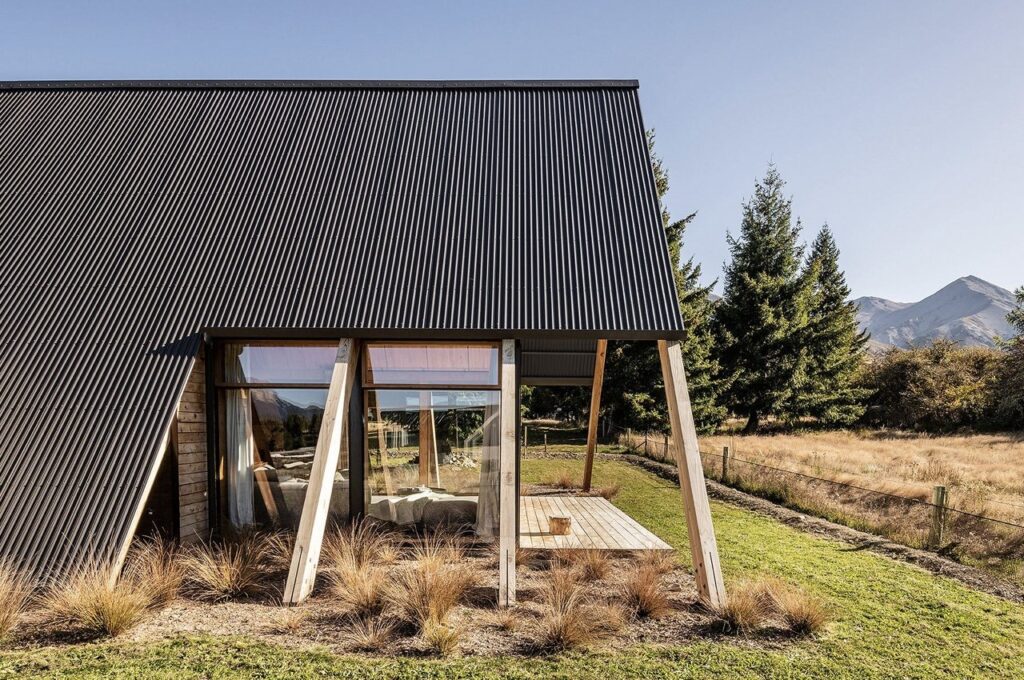 Exterior view of Adventure Whare resort surrounded by trees and forests, featuring traditional A-frame design with modern touches.