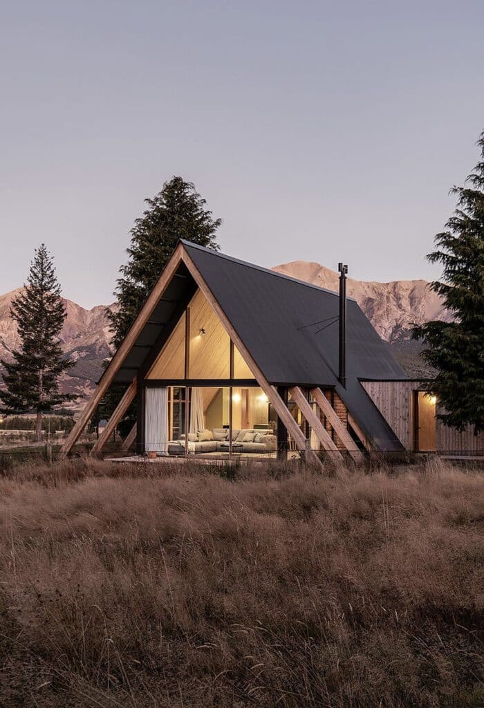 Exterior view of Adventure Whare resort surrounded by trees and forests, featuring traditional A-frame design with modern touches.