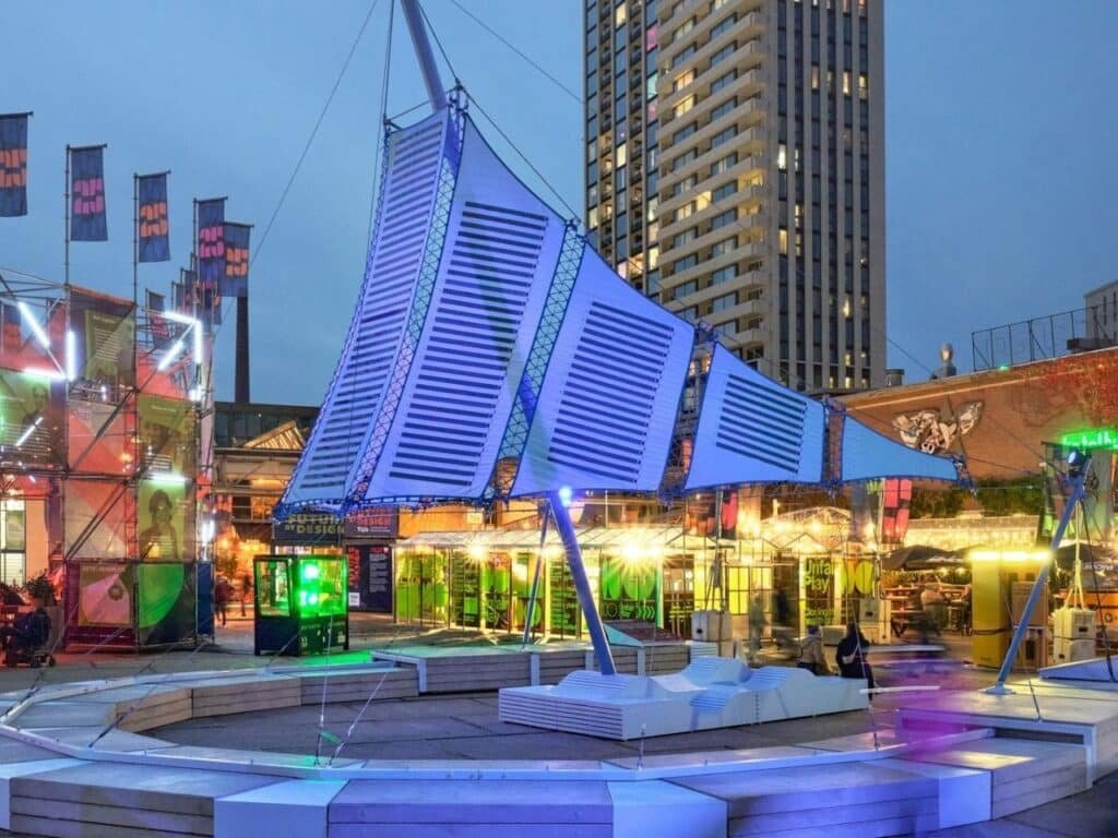Umbra Pavilion facade with sky-blue roof and Heliotex solar materials