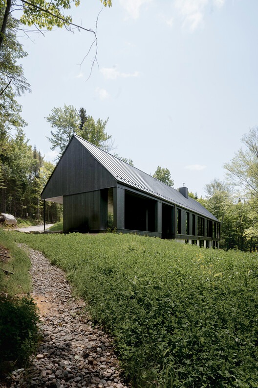 Residential building in Laurentians integrated with surrounding nature and interior spaces.