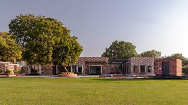Brick House façade in New Delhi showing graduated brick patterns and trellis structure.