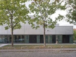 Indoor swimming pool at Sportbad am Rabet project in Leipzig, showing modular design, use of glass and exposed concrete, and open spaces integrated with nature and urban context.