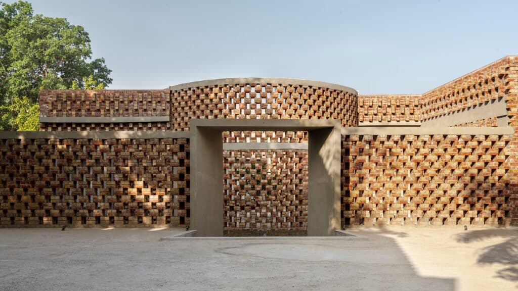 Brick House fa&ccedil;ade in New Delhi showing graduated brick patterns and trellis structure.