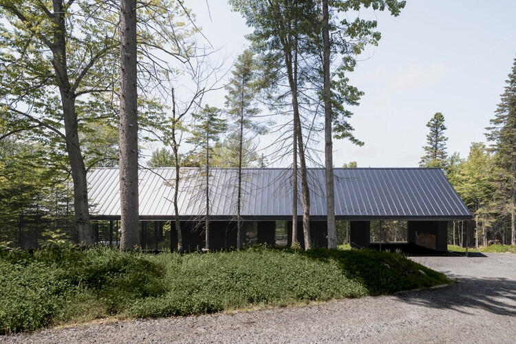 Residential building in Laurentians integrated with surrounding nature and interior spaces.