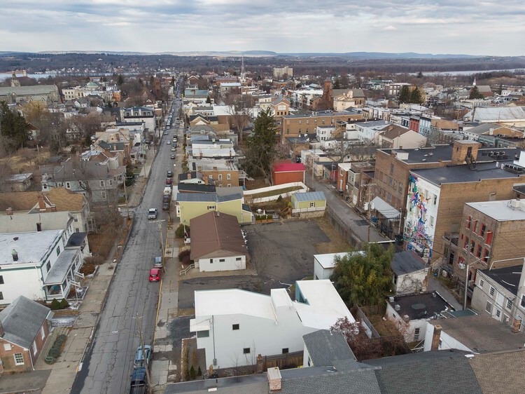 L-shaped house fa&ccedil;ade clad in corrugated aluminum reflecting sunlight