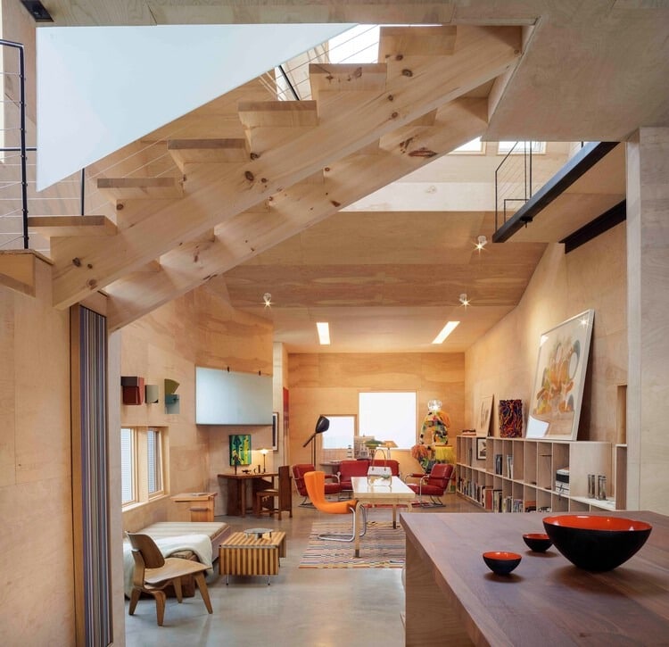 L-shaped house fa&ccedil;ade clad in corrugated aluminum reflecting sunlight