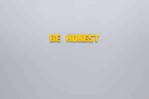 Simple yellow text 'Be Honest' on a neutral background, emphasizing clarity and inspiration.