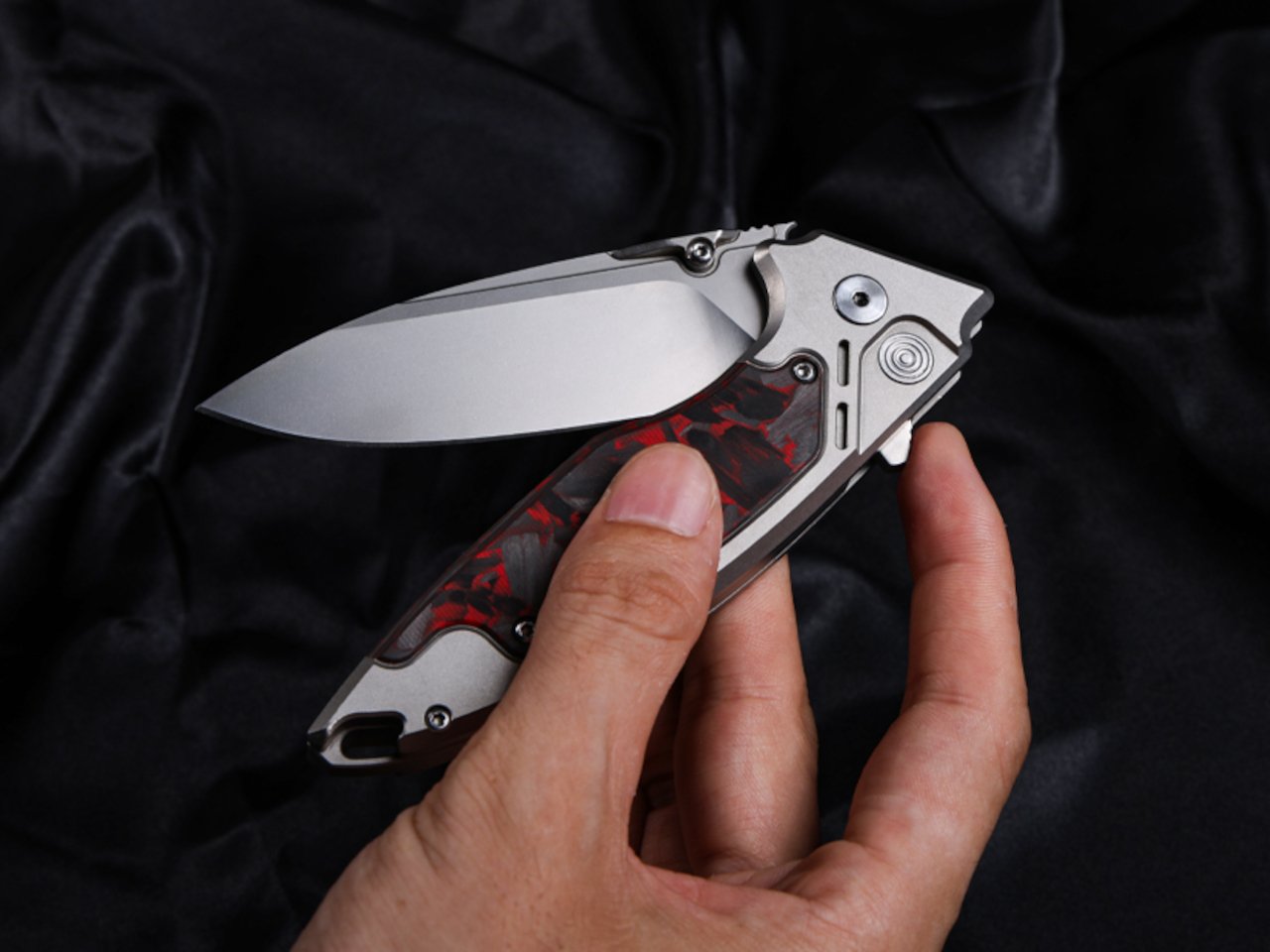 Close-up of the Scarab 2.0 EDC knife showing carbon fiber and titanium materials