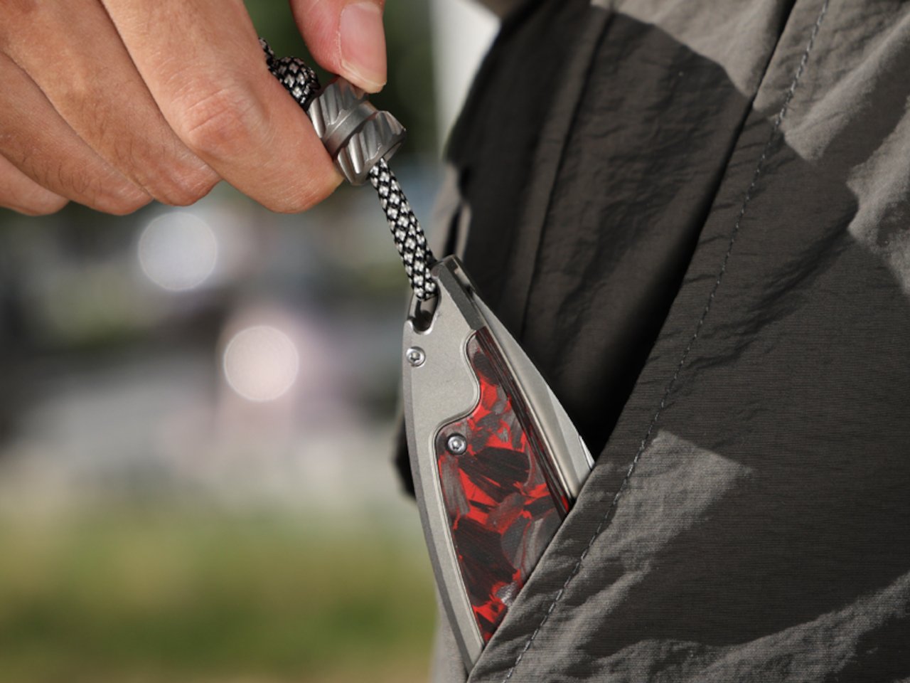 Close-up of the Scarab 2.0 EDC knife showing carbon fiber and titanium materials