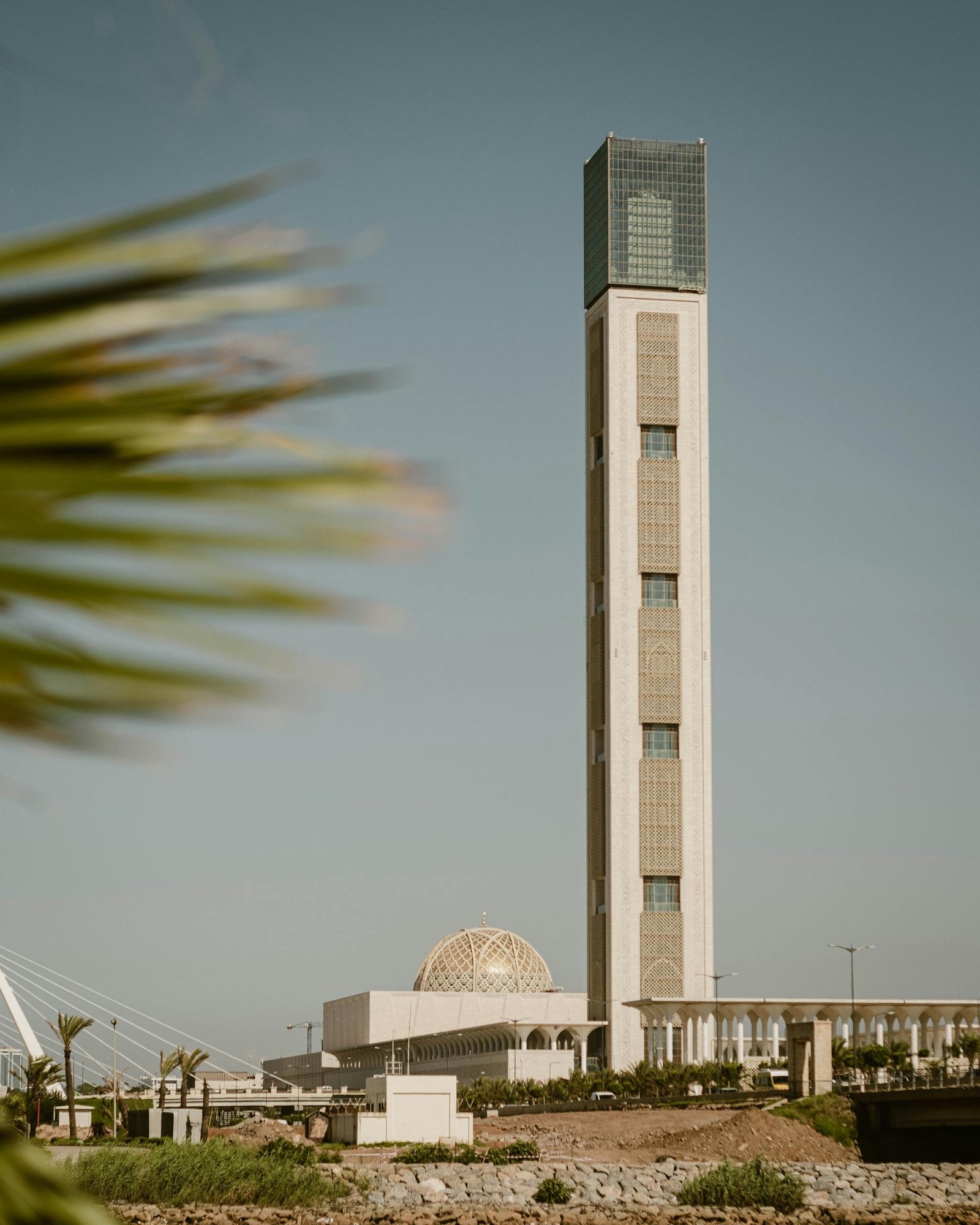 Vertical shot of the Djamaâ El Djazaïr minaret in Algiers under a clear sky, showcasing Islamic architecture.
