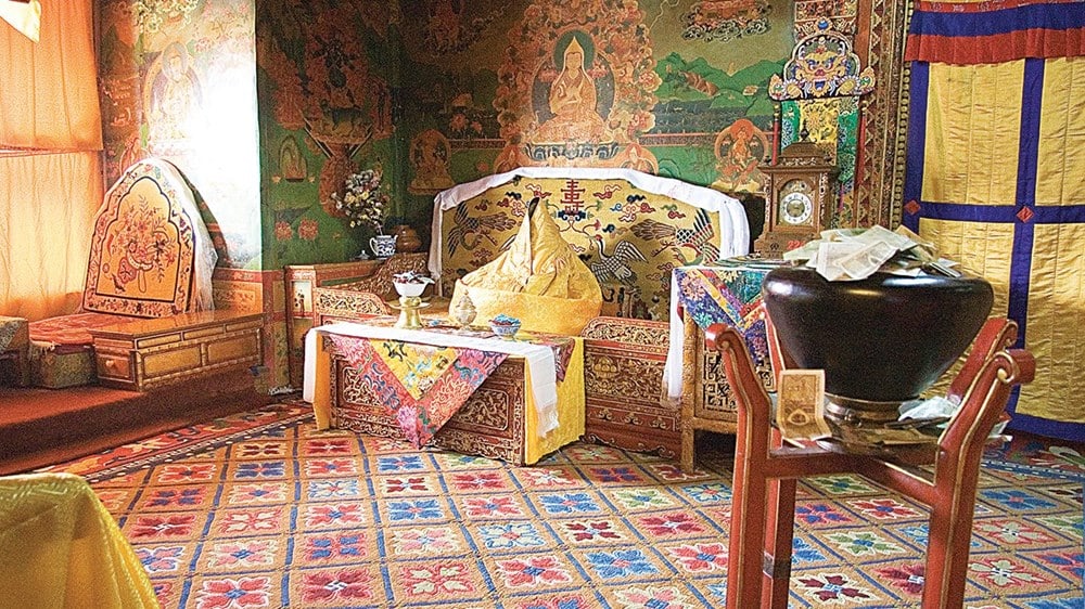 Interior hall of Potala Palace featuring golden altars and intricate wall paintings.