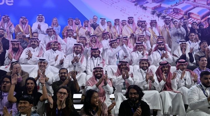 ضوء دافئ يلامس الوجوه، وجوه تبتسم بين الحضور في قاعة مفعمة بالطاقة.