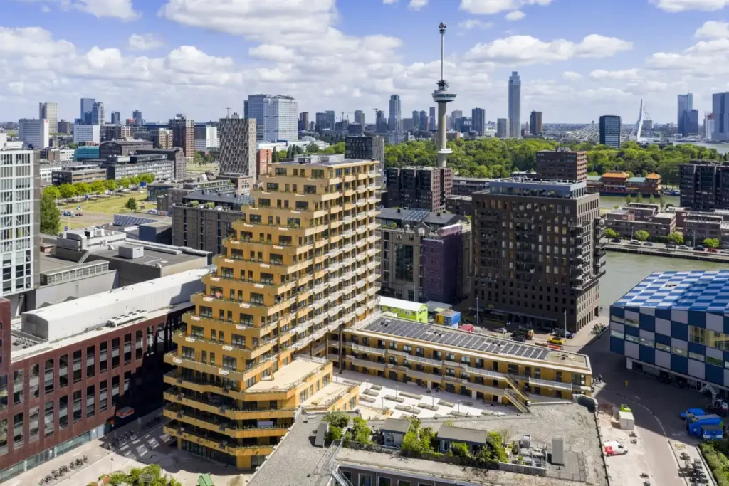 مبنى خشبي متدرج يندمج مع أفق روتردام، يضفي دفئًا طبيعيًا وحيوية.