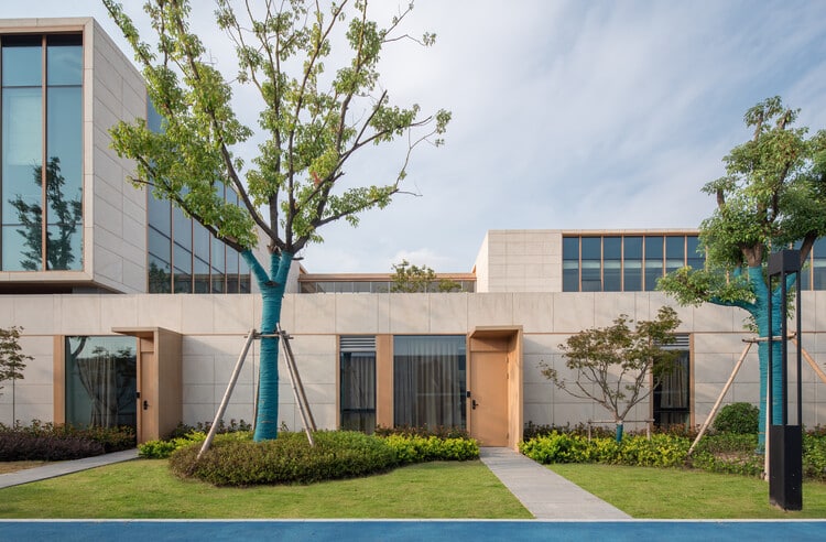Glass facades of interconnected buildings in the retirement community, showing elevated pathways linking units and internal corridors.