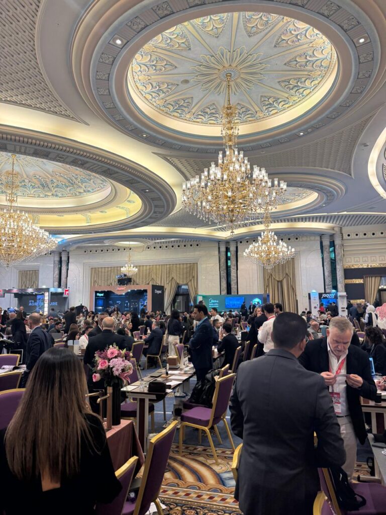 مشاركون في قمة جدة للعقارات يجتمعون تحت سقف فخم وزخارف ذهبية وأزرق.