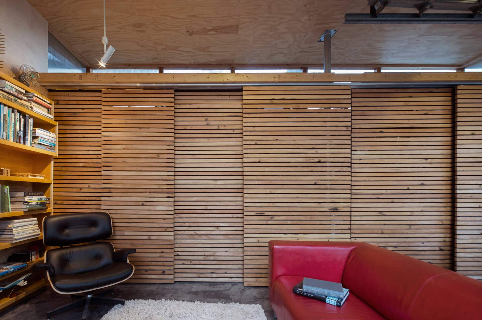 أبواب الحظيرة المنزلقة الذكية تخفي مساحة التخزين والحمام الصغير، مما يضيف وظيفة دون فوضى.