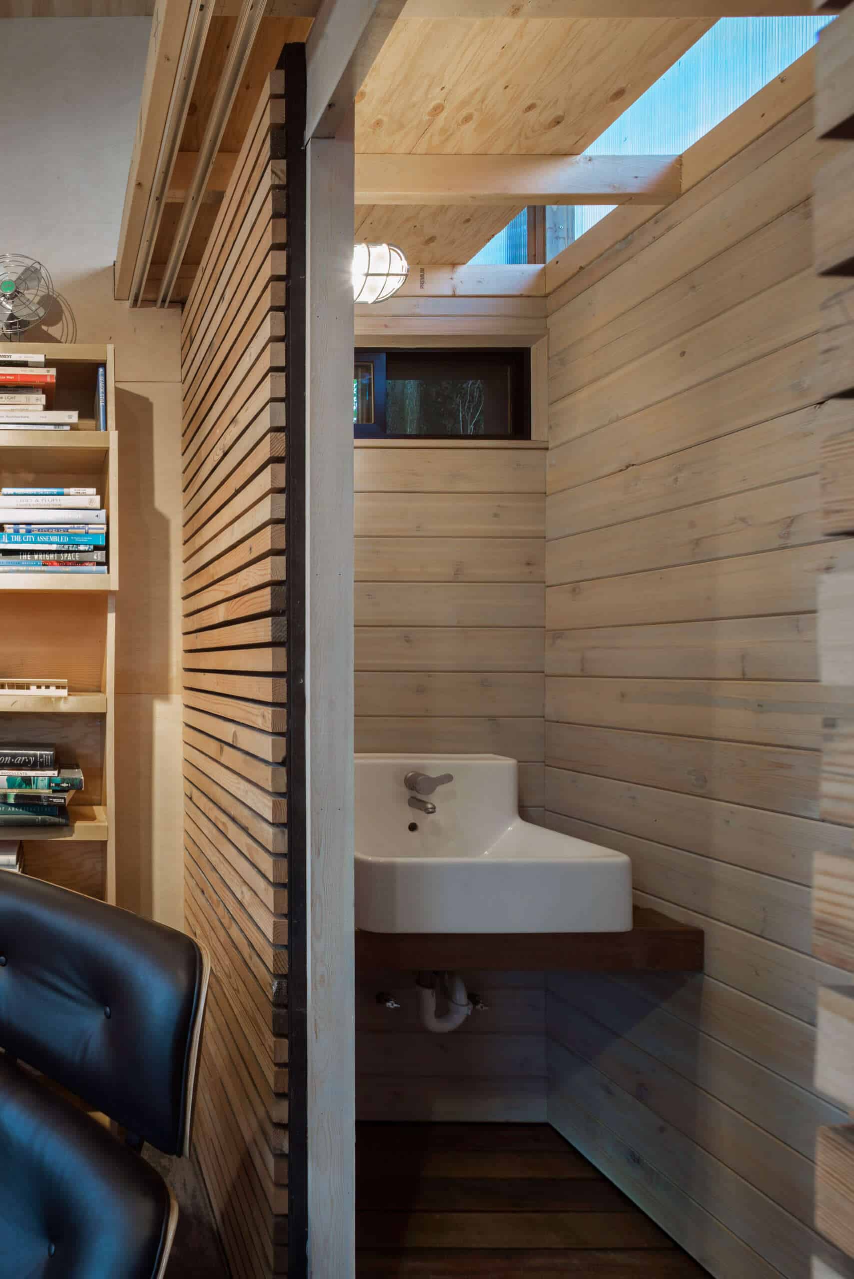 أبواب الحظيرة المنزلقة الذكية تخفي مساحة التخزين والحمام الصغير، مما يضيف وظيفة دون فوضى.