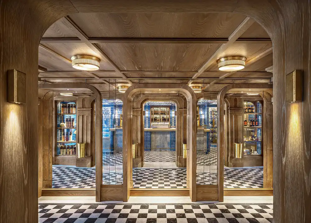  Elegant entry to Past&eacute;is de Bel&eacute;m&rsquo;s expansion wood, blue tiles, checkered floor, golden light.