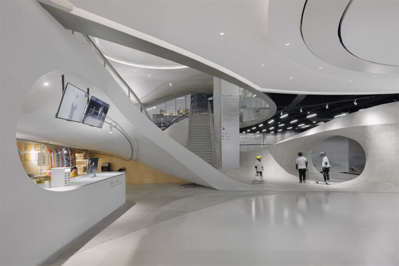 Long undulating bowl inside the indoor skatepark with ramps designed for varied skating speeds.