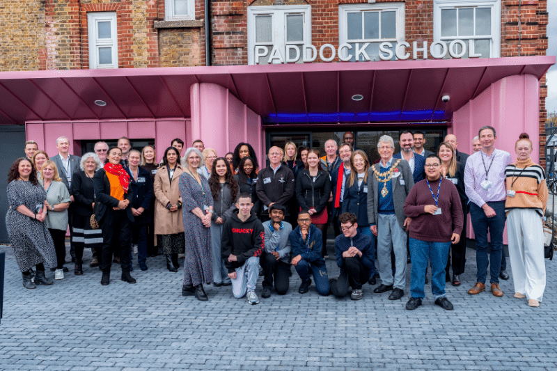 الطلاب والزوار يتجمعون أمام مدخل المدرسة مع الضوء الطبيعي الممتد