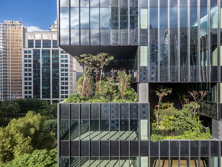 Low-angle view of Salma Tower with transparent glass façades and green terraces