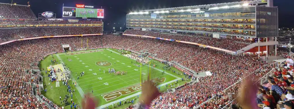 مشهد ليلي لمدرجات ملعب ليفيالممتلئة بالجماهير، مع إضاءة ملعب مذهلة وشاشة عملاقة تضيء الليل.